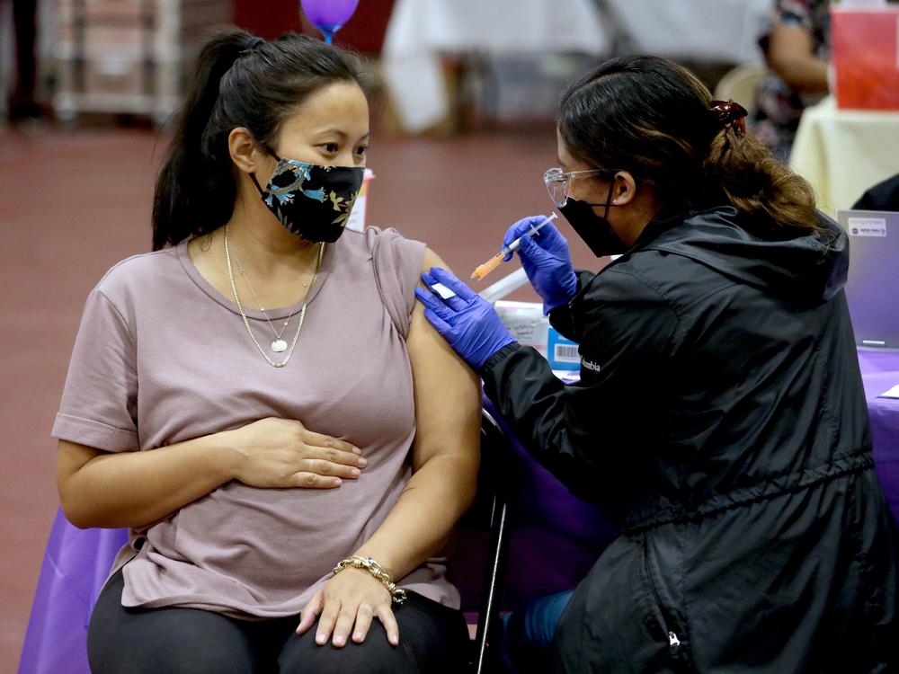 Nicole Fahey, six months pregnant, receives a Pfizer vaccination from a nurse on Nov. 3, 2021 in Los Angeles, CA.