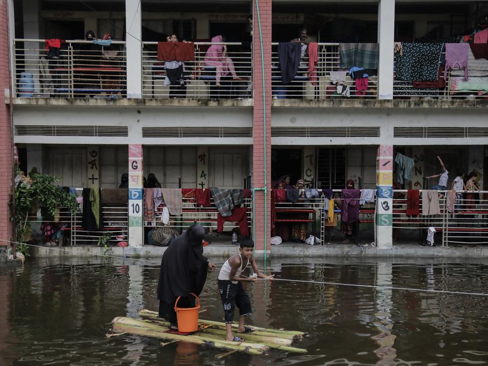 People use boat made out of banana branches to commute from temporary flood shelter camp to the main street to buy daily essential in Feni, Chittagong, Bangladesh, August 26.