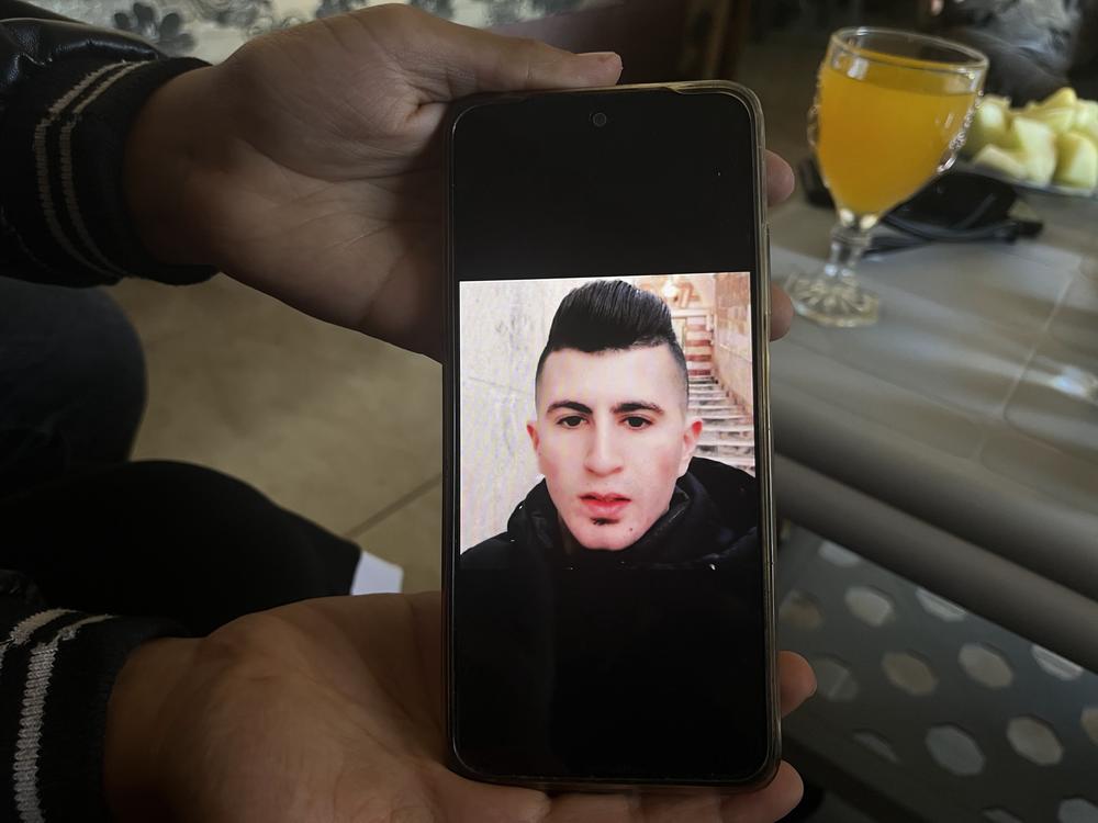 A photo of Ahmad Abu Markhiya is displayed on a relative's phone.