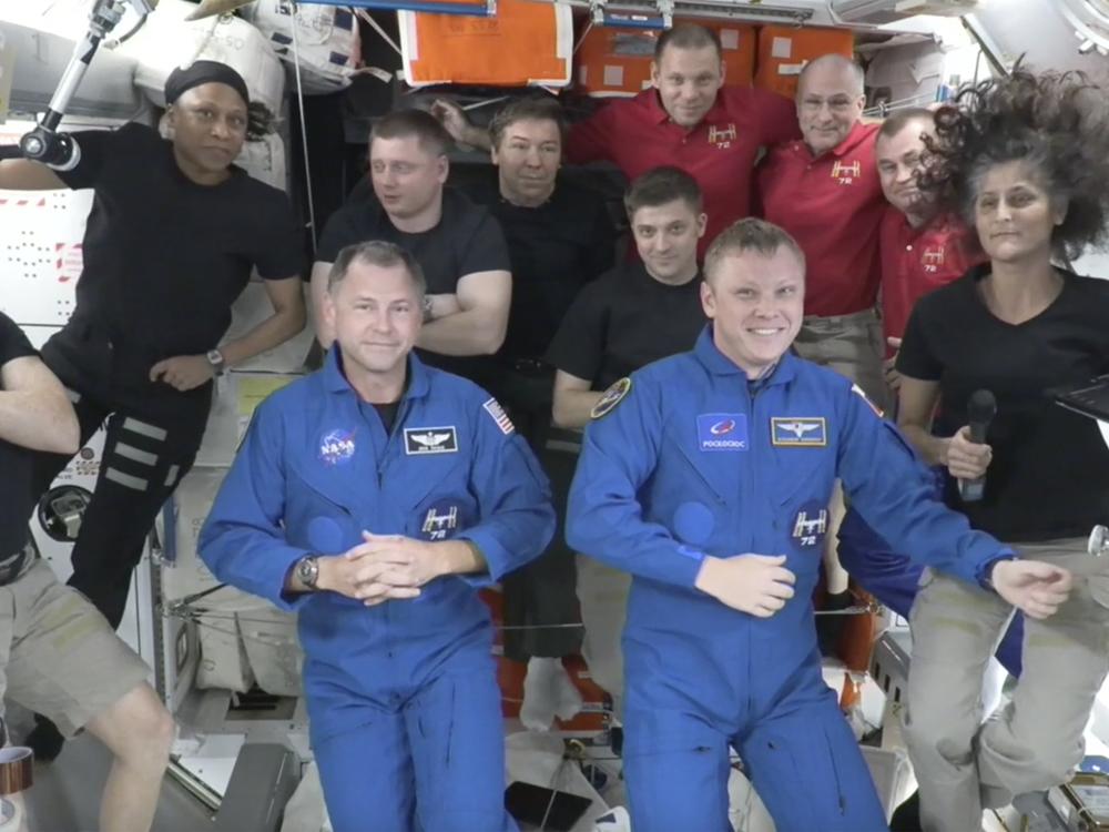 Butch Wilmore, far left, and Suni Williams, far right, welcome Nick Hague, front left in blue, and Alexander Gorbunov, front right in blue, on Sunday. Behind them, from left in black, are NASA's Jeanette Epps, Russia's Alexander Grebenkin, NASA's Mike Barratt and NASA's Matthew Dominick. From left, in red, are Russia's Ivan Vagner, NASA's Don Pettit and Russia's Alexei Ovchinin.