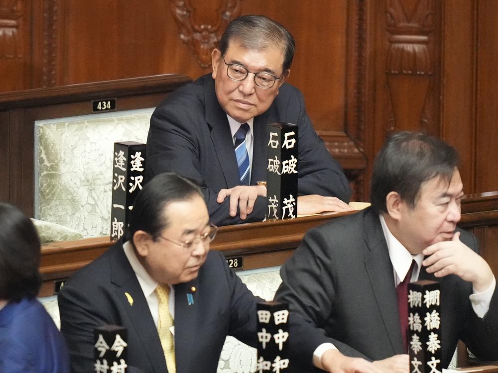 Japan's outgoing Prime Minister Fumio Kishida stops as media members asked him to make a comment before he leaves the prime minister's office in Tokyo Tuesday, Oct. 1, 2024.