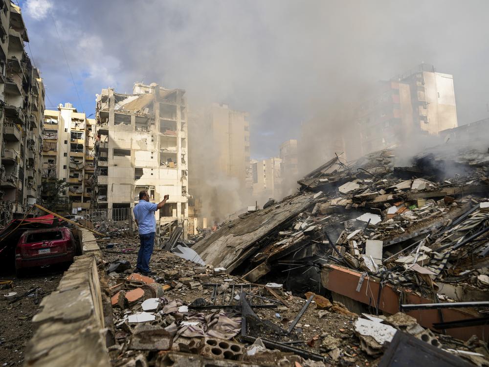 A man documents destroyed buildings at the site of an Israeli airstrike in Beirut's southern suburb, Lebanon, on Tuesday.