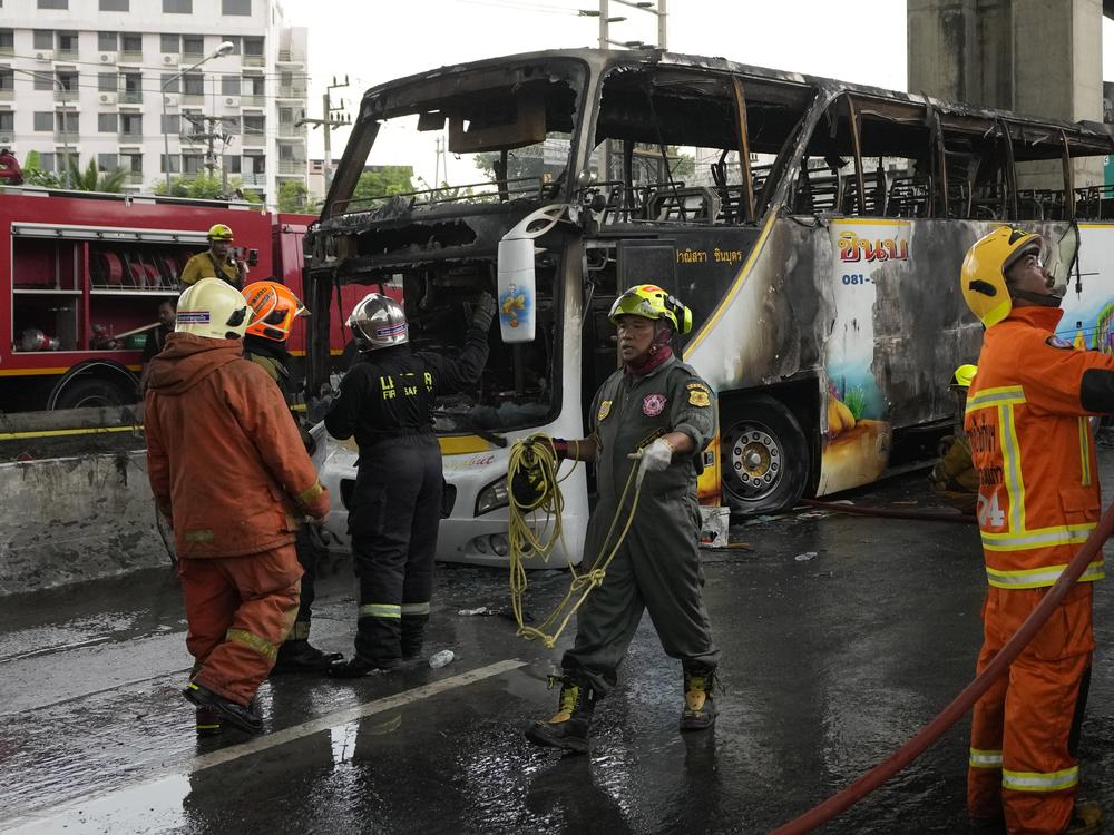 Rescuers work at the site of a bus that caught fire, carrying young students with their teachers, in suburban Bangkok on Tuesday.