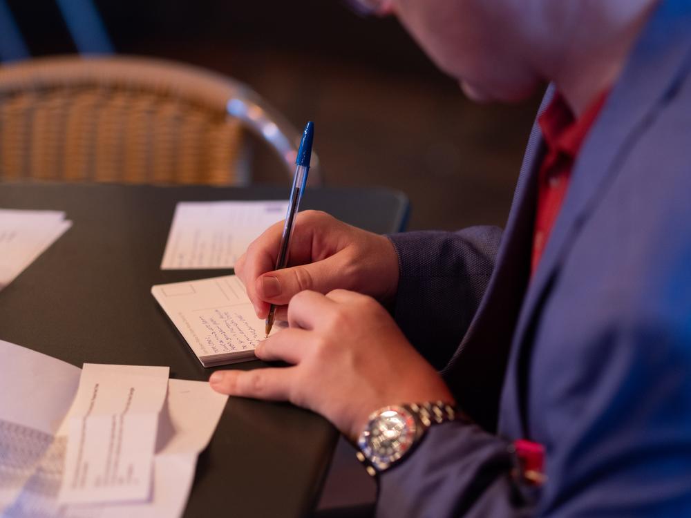 A member of the Young Republicans fills out a postcard asking for support for GOP candidates in Georgia.