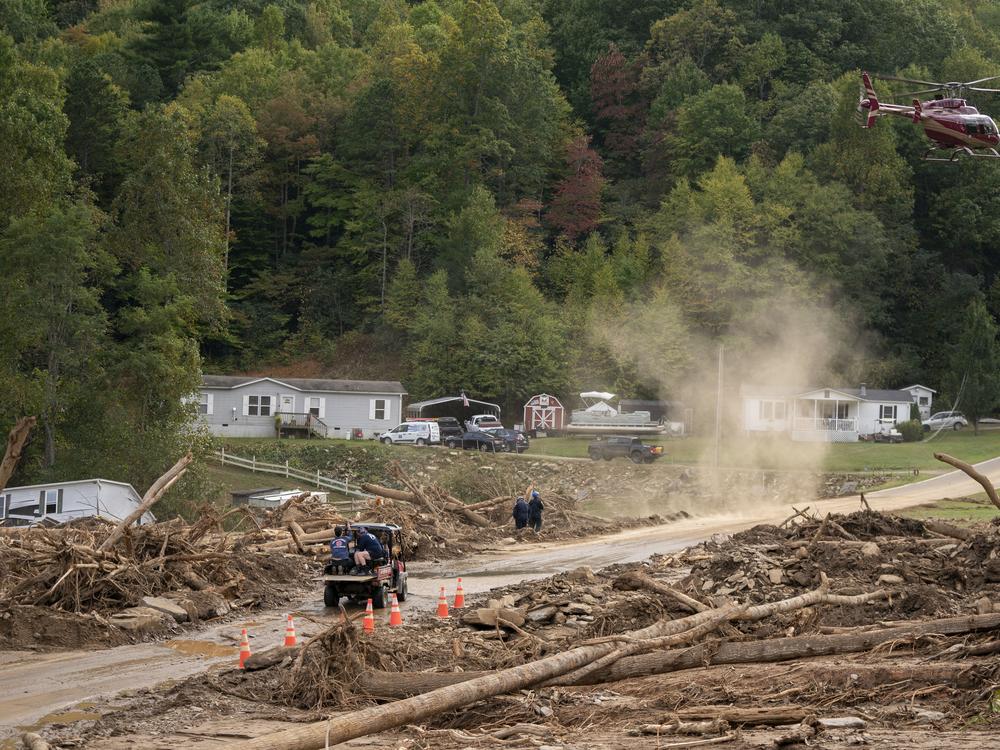 A helicopter lands in a yard near Black Mountain, N.C., in the aftermath of Hurricane Helene on Monday.