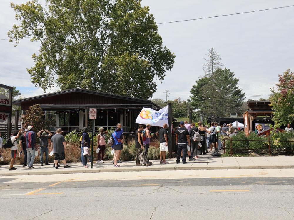 People in Asheville, N.C., line up for a meal outside Bear's Smokehouse BBQ on Monday.