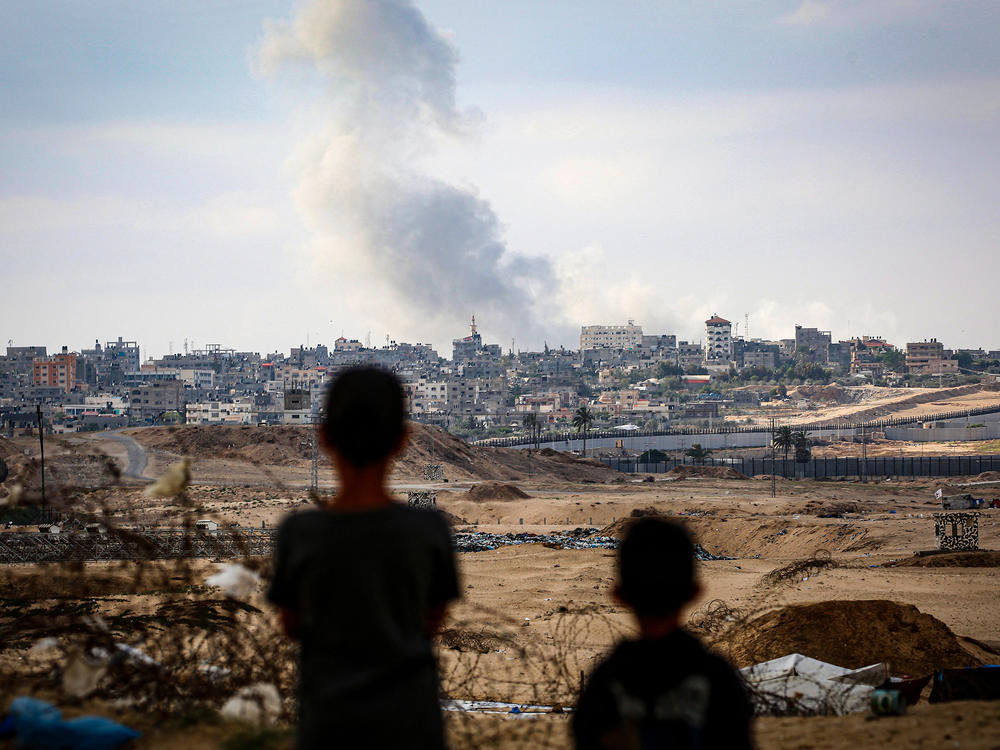 Boys watch smoke billowing during Israeli strikes east of Rafah in the southern Gaza Strip on May 13.