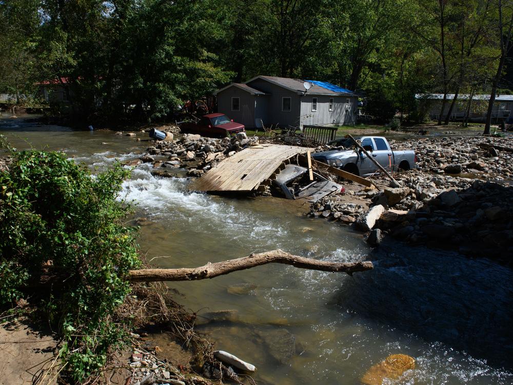 Damage to homes and vehicles along with evidence of rerouted streams can be seen on Oct. 2 in Black Mountain, N.C. The road can be seen washed out from floodwaters in front of his property. According to reports, at least 160 people have been killed across the southeastern U.S., and more than a million are without power due to the storm. The White House has approved disaster declarations in multiple Southern states, freeing up federal emergency management money and resources.