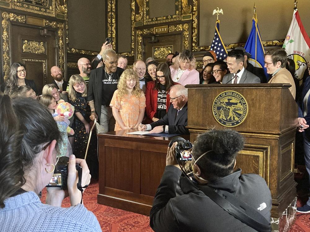 Democratic Minnesota Gov. Tim Walz signs an executive order on March 8, 2023, at the State Capitol in St. Paul, Minn., to protect the rights of LGBTQ people from Minnesota and other states to receive gender-affirming health care.