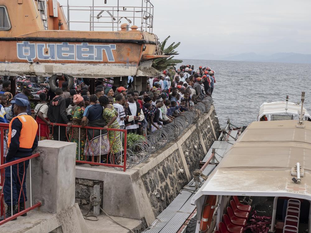 People gather at the port of Goma, Democratic Republic of Congo, after a ferry carrying hundreds capsized on arrival Thursday.