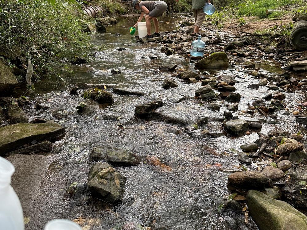 Residents of the Asheville collect water to use in their homes along the Reed Creek Greenway. <br>