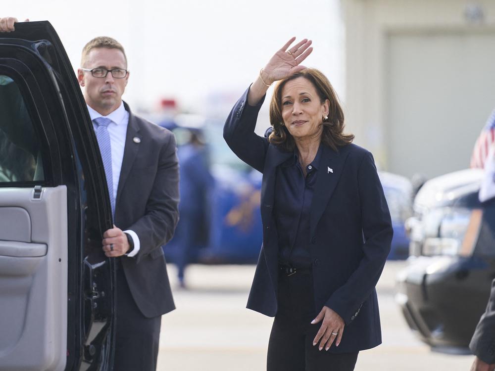 Vice President Harris waves after landing in Flint, Mich., on Oct. 4.
