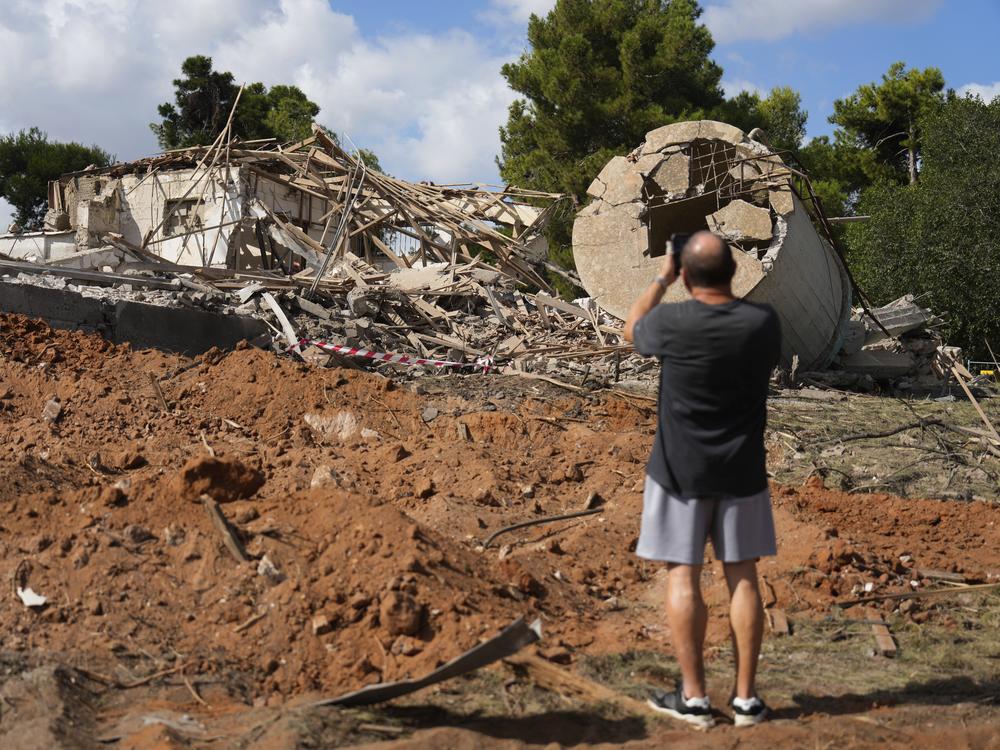 A man takes photos of a destroyed building that was hit in Iran's missile attack in Hod Hasharon, Israel, Wednesday.