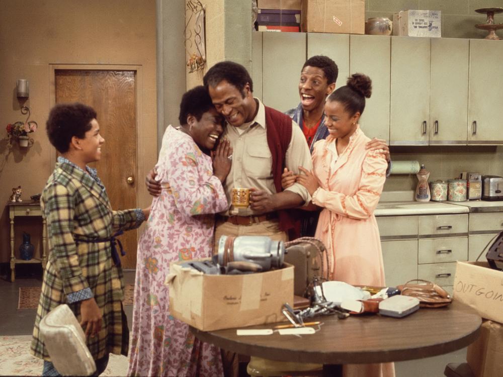 Ralph Carter, Esther Rolle, John Amos, Jimmie Walker, and BernNadette Stanis gather in the kitchen during a scene from <em>Good Times</em> in 1975.