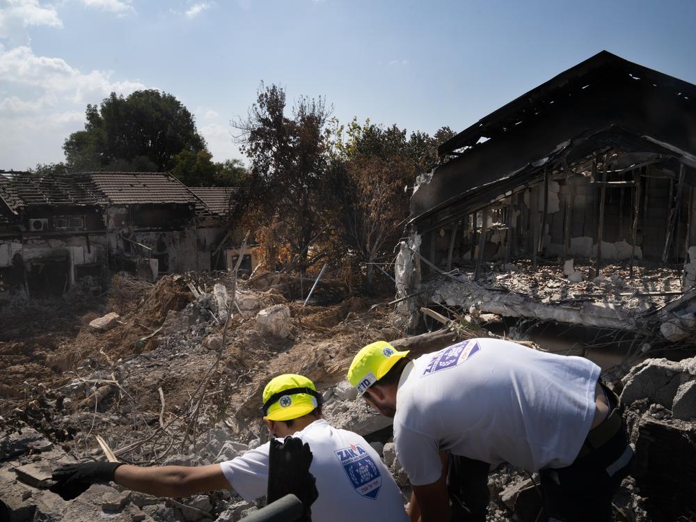 Men working with a search and recovery team from the organization Zaka look for human remains in Kibbutz Be'eri, in Israel on Oct. 20, 2023.