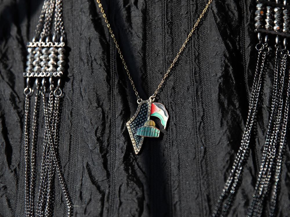 Samra’a Luqman, an activist and community organizer, wears a necklace showing the state and flag of Palestine on Tues., Oct. 1, 2024 at Haraz Coffee in Dearborn, Mich.