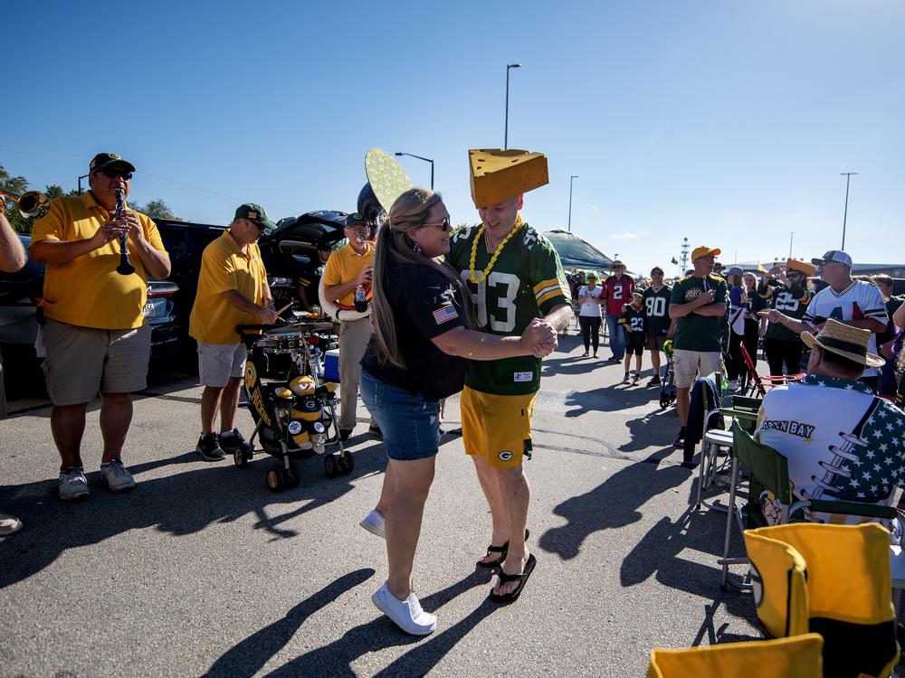 Packers fans Heather Gunnlaugsson, left, and Tim Mahoney, right, dance as the Packer Tailgate Band plays “Roll Out the Barrel” on Sunday, Sept. 29, before the Packers’ game against the Minnesota Vikings in Green Bay, Wis.