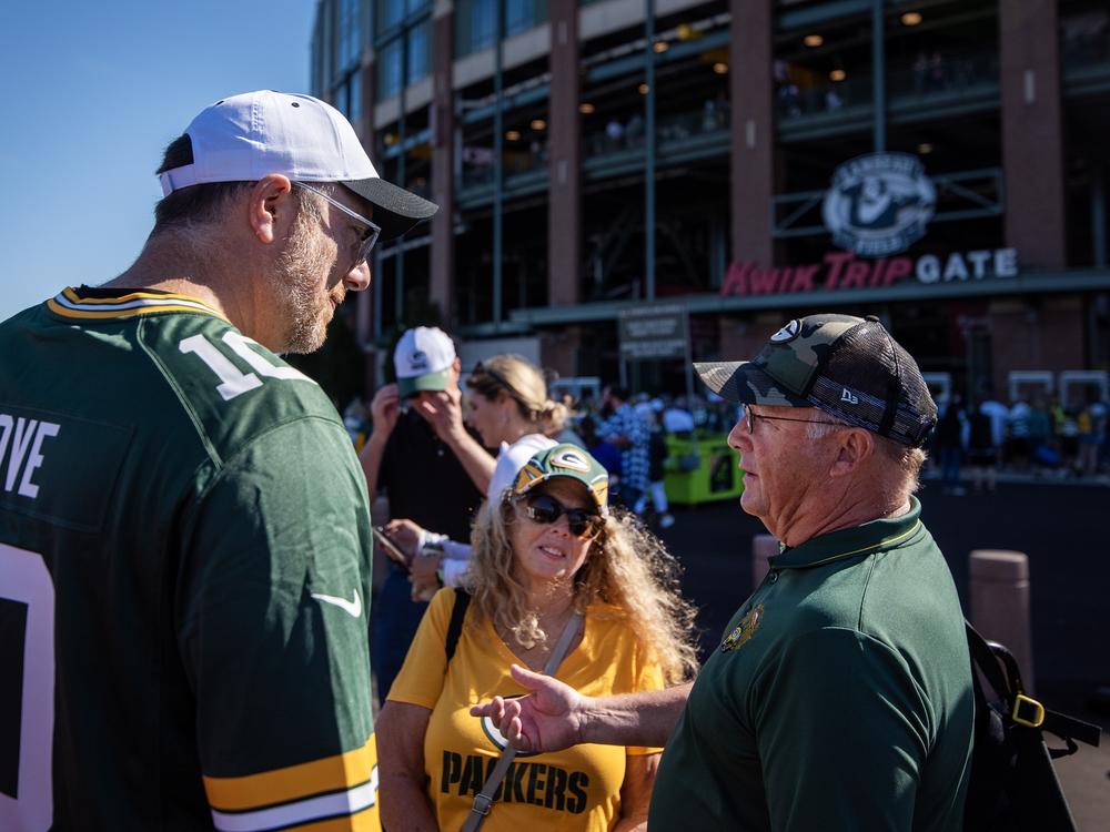 Democratic Party of Wisconsin Chairman Ben Wikler, left, speaks to Denise Gaumer Hutchison, center, a Democratic voter from Green Bay, outside Lambeau Field on Sunday, Sept. 29.