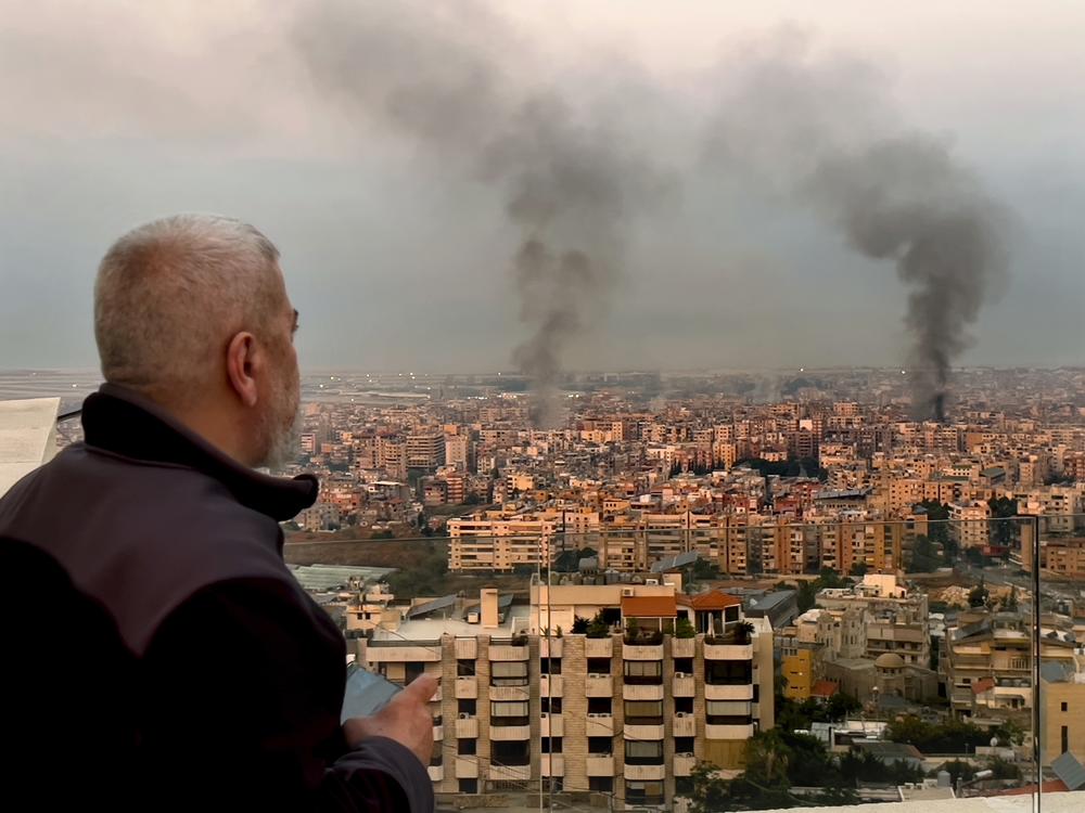 A man looks as smoke rise from Israeli airstrikes in Dahiyeh, Beirut, Lebanon, early on Sunday.