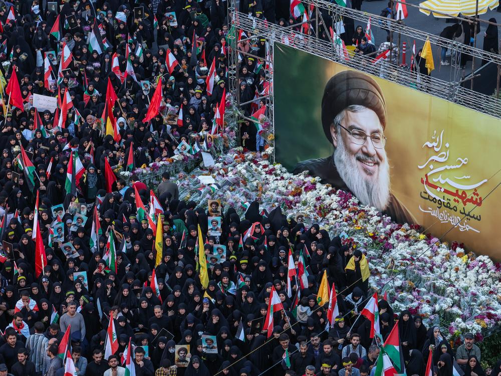During an anti-Israel protest in Tehran, Iran, on Sept. 30, Iranians lay flowers beneath a billboard bearing a portrait of Hezbollah leader Hassan Nasrallah, who was killed in an Israeli airstrike on Beirut's southern suburbs on Sept. 27.