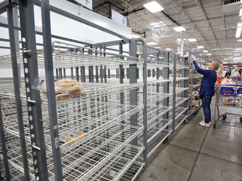 Customers check mostly empty bread shelves at a shopping warehouse in Kissimmee, Florida on Sunday.