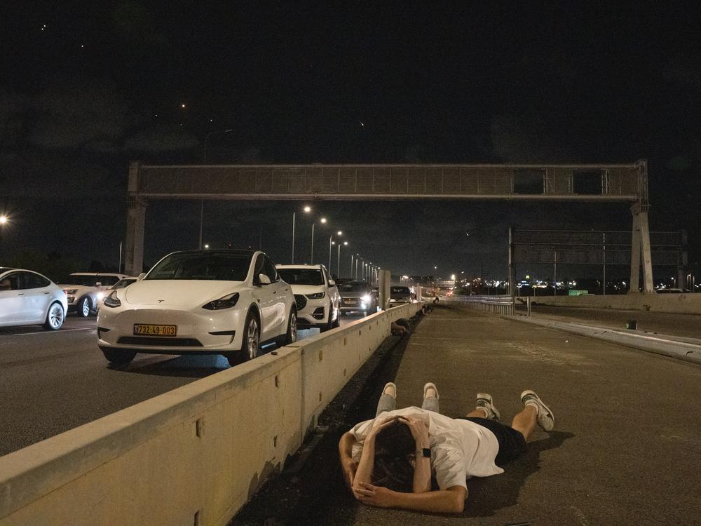 Israelis shelter on the highway during a massive missile barrage from  Iran on Tuesday Oct. 1.