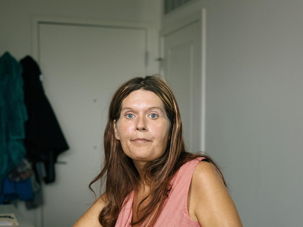 Christina Cooley, who requires a cane to walk and is on disability, poses for a portrait in her apartment in The Laureate, a luxury apartment building in Derwood, Md. She says she appreciates the building’s accessibility features.