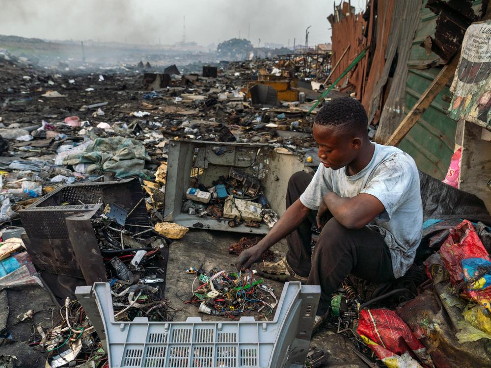 Emmanuel Akatire, 20, roams around e-waste processing areas with a sack, sorting through discarded e-waste materials and separating them by material — copper, iron and aluminum — for sale.