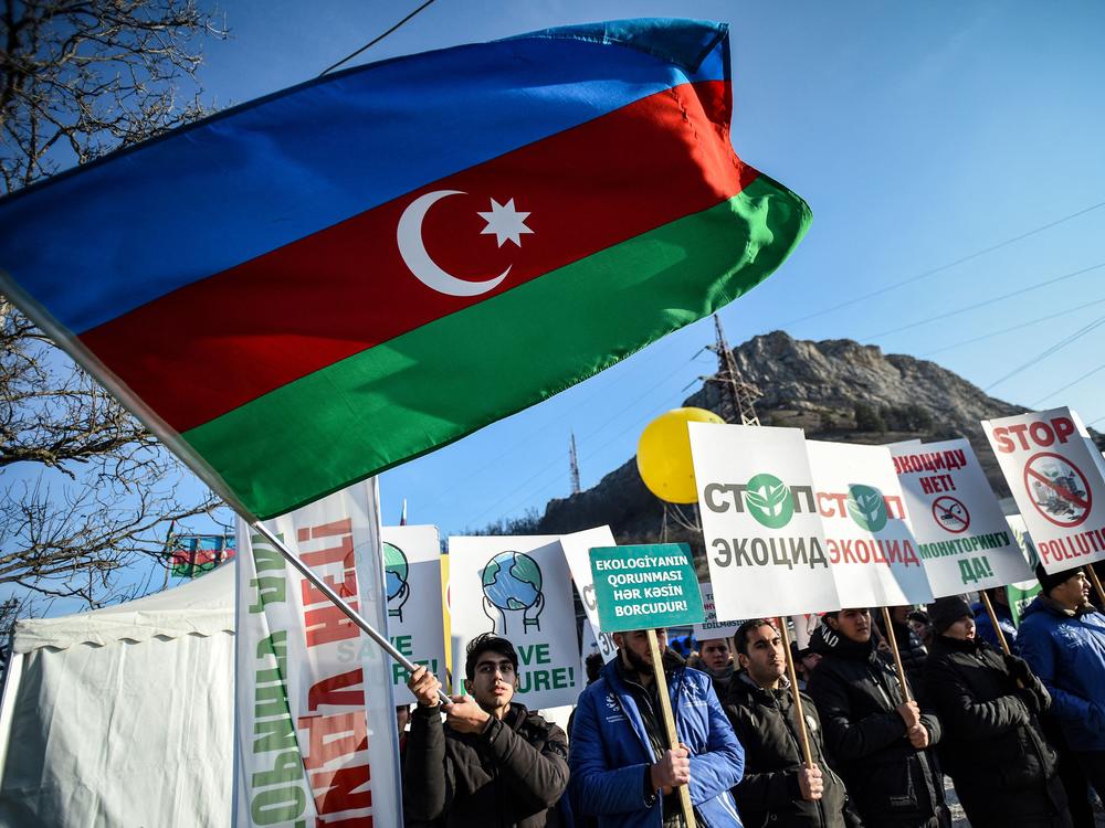 An Azerbaijani environmental activist waves a national flag during a protest against what they claim is illegal mining at the Lachin corridor, the only land link between the Armenian-populated breakaway Nagorno-Karabakh region and Armenia.