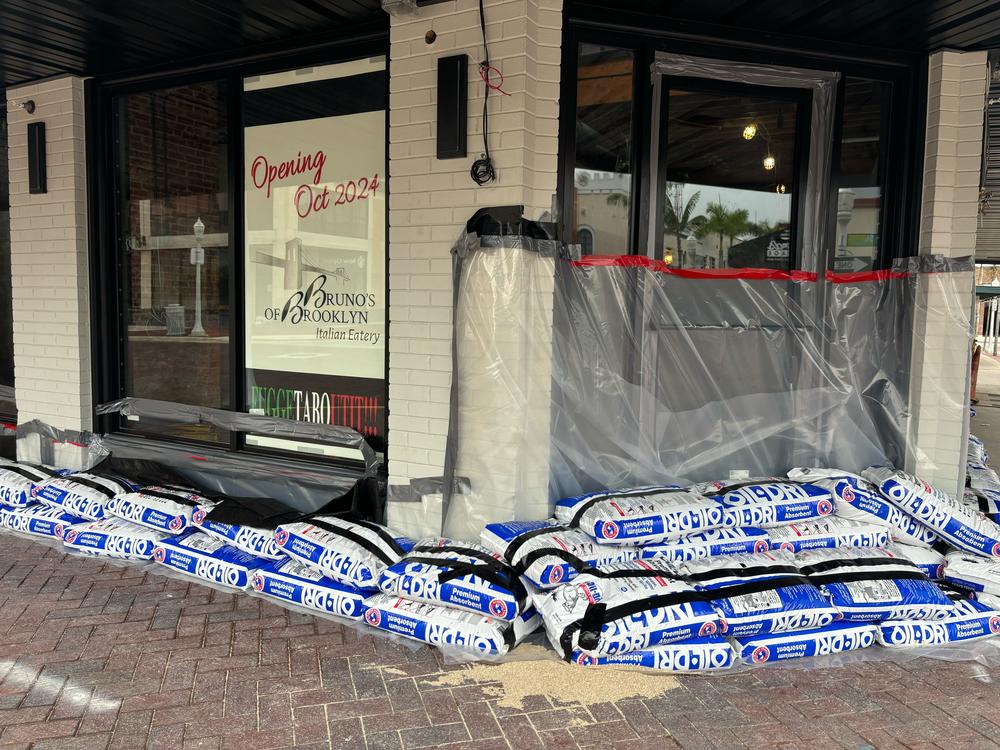 In downtown Fort Myers, Fla., plywood panels and sand bags protect businesses ahead of Hurricane Milton's landfall.
