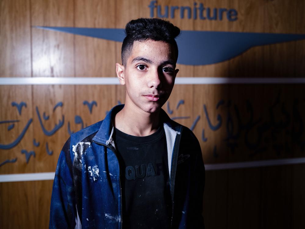 Noor Assi, 15, in the carpentry shop where he works.
