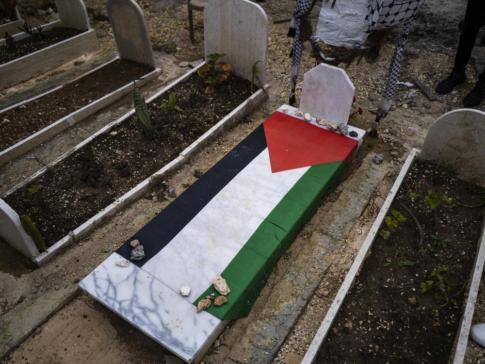 Ahmed Assi’s grave is draped in a Palestinian flag.