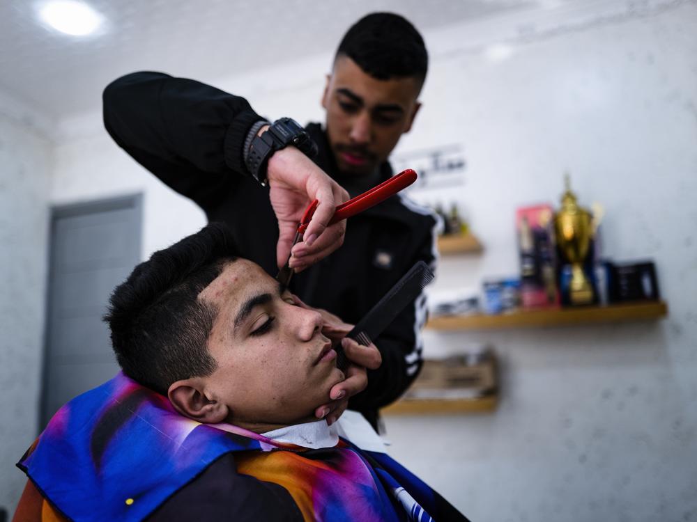 Noor gets a haircut in his local barbershop.