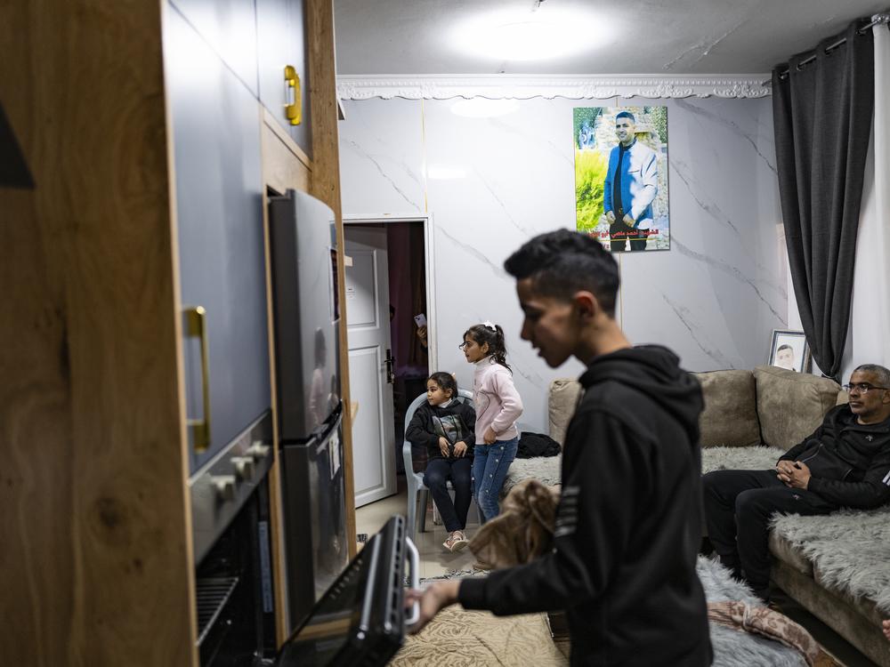 Noor opens the oven before family dinner. His mother is teaching him to cook.