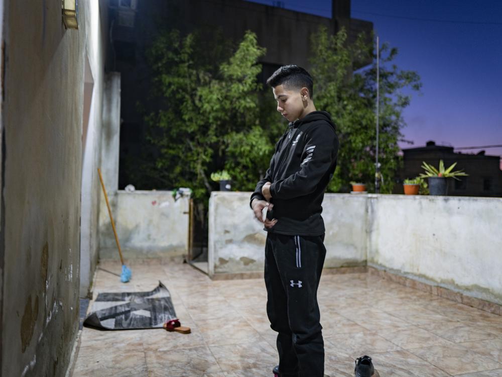 Noor praying on his patio. Prayer is important to Noor, from day to night.