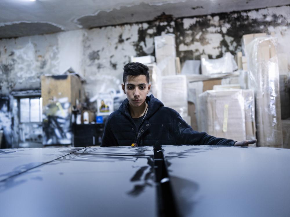 Noor Assi, in the carpentry shop where he works.