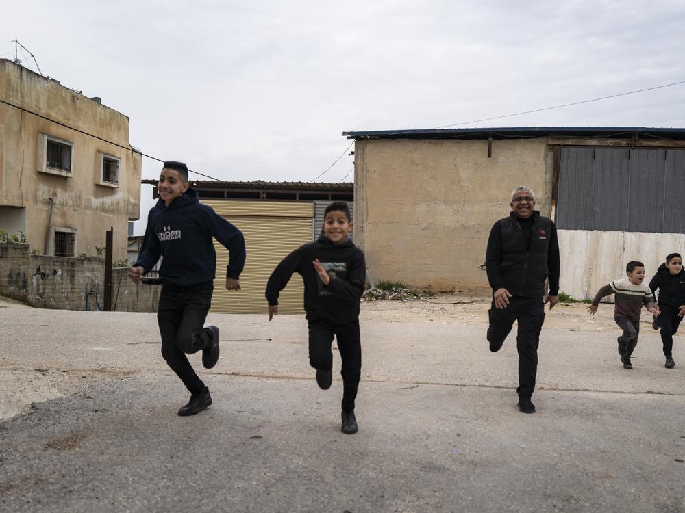 Noor playing with his family outside his home.