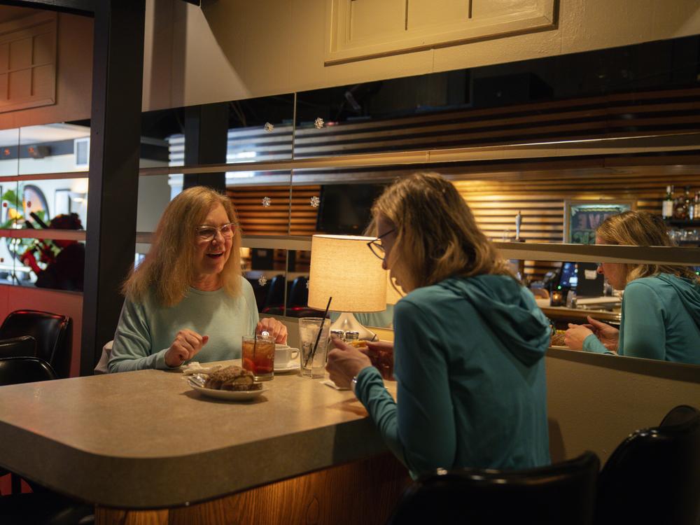 Janine Collette (left) catches up with a friend, Hannah Yancy Pierce.