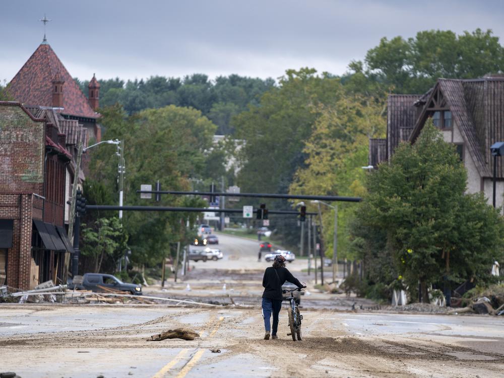 A woman walks along a road in Asheville.
