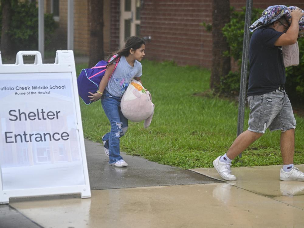 People arrive to shelter at Buffalo Creek Middle School in Bradenton, Fla., ahead of Hurricane Milton's expected landfall on Oct. 9, 2024.