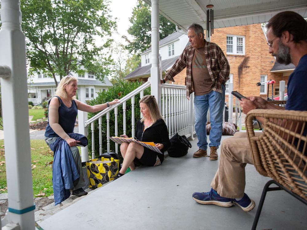 Trey Moore (right) holds a neighborhood meeting on his front porch in Erwin, Tenn., to plan how to help with flood relief in Poplar, N.C. From left are Ruth Bell, Melissa Barnes and Dave Bell. Moore has rallied support from the whitewater paddling community that passes through Poplar to raft the Nolichucky River.