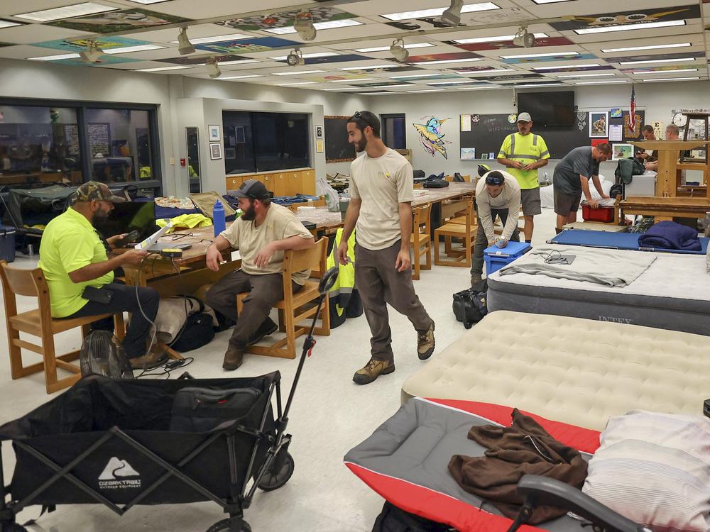 Members of Pasco County utilities set up in classrooms in a hurricane shelter at River Ridge Middle/High School in preparation for Hurricane Milton in New Port Richey, Fla., on Wednesday.