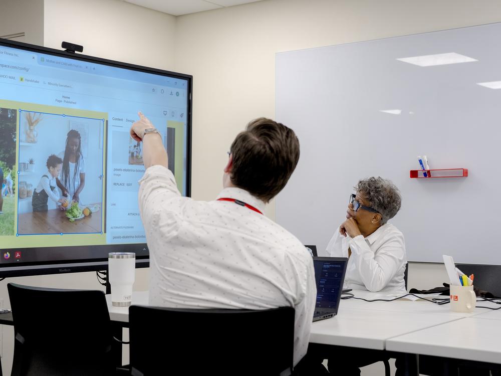 Zach Huber, left, and Marsha Hill work together in the small business and nonprofit workspace at the Toledo Lucas County Public Library in Toledo, Ohio on Oct. 3, 2024. Huber was assisting Hill with creating her website for her nonprofit, Families For Fitness.