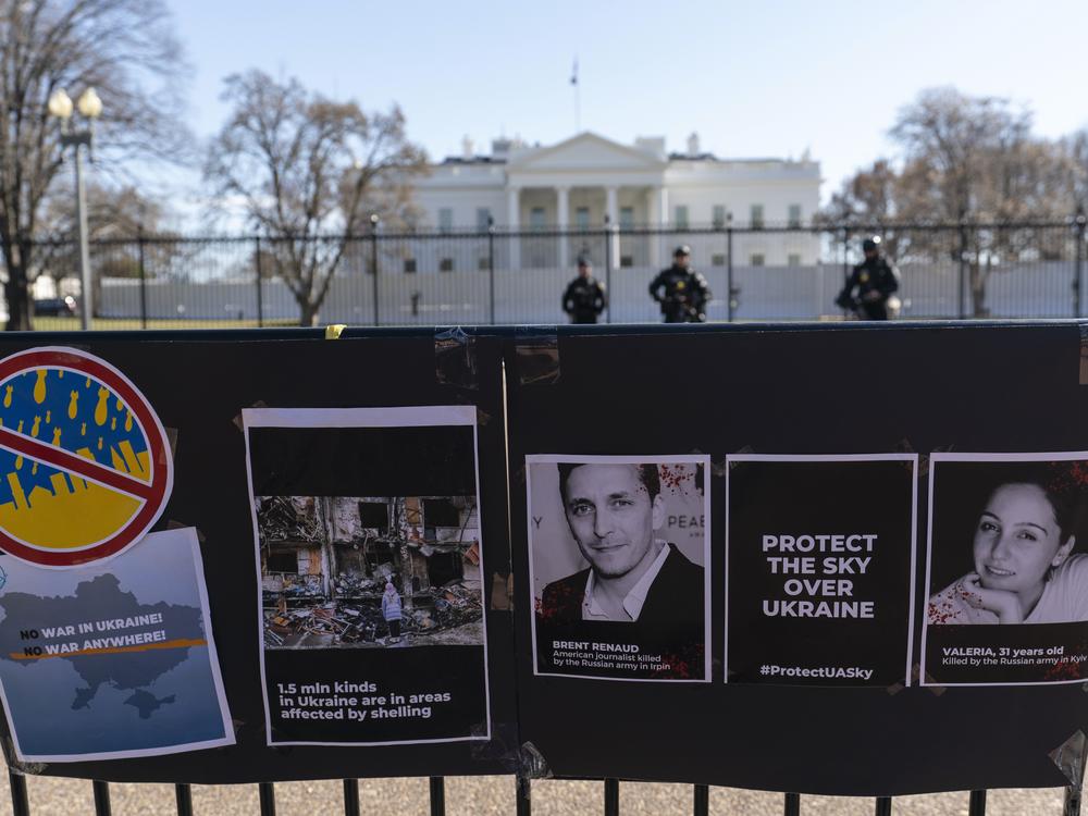 Signs and pictures of those killed, including journalists, are displayed on a fence during a protest against Russia's invasion of Ukraine in Lafayette Park near the White House on March 13, 2022, in Washington.