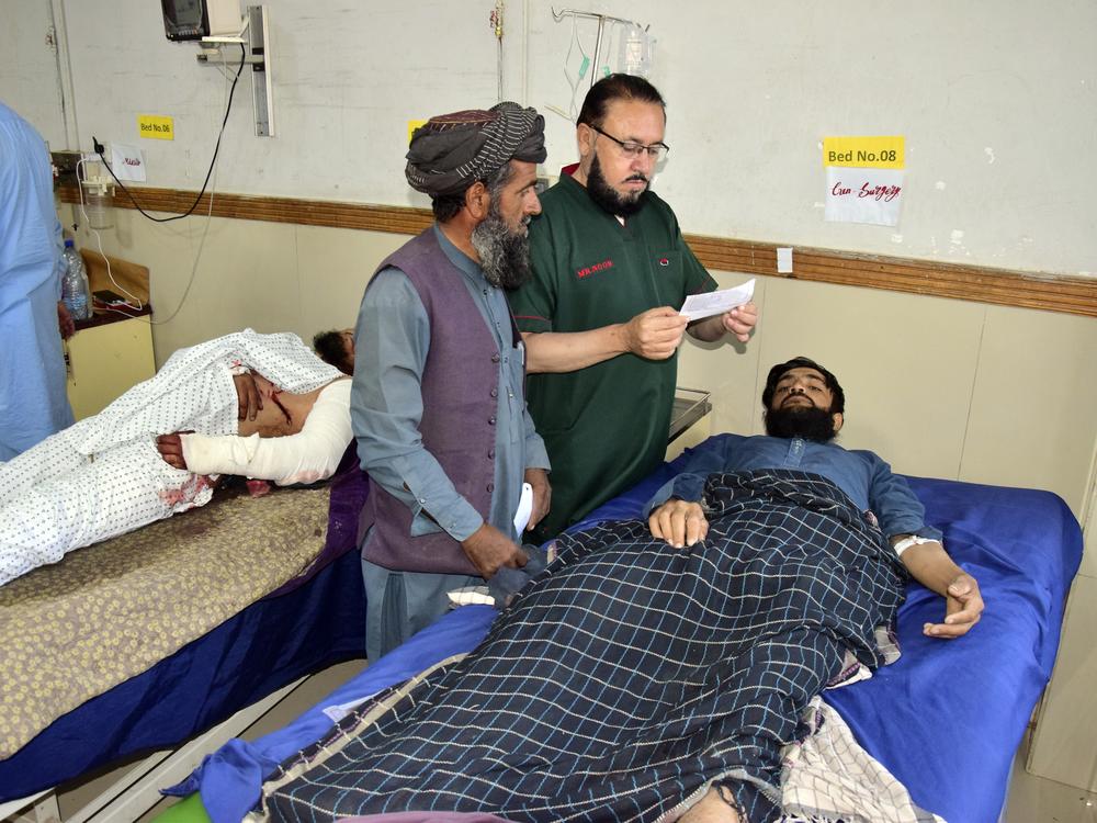 Injured men receive treatment at a hospital in Quetta, Pakistan, on Friday following the Thursday attack by gunmen in Balochistan province.