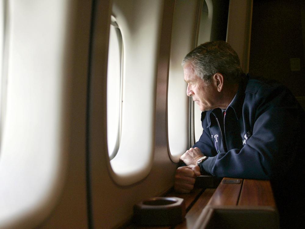 President George W. Bush looks out the window of Air Force One on August 31, 2005, as he surveys Hurricane Katrina damage over New Orleans on his way from Texas to Washington, D.C.  The photo and flyover were widely panned, and he later called them a mistake.