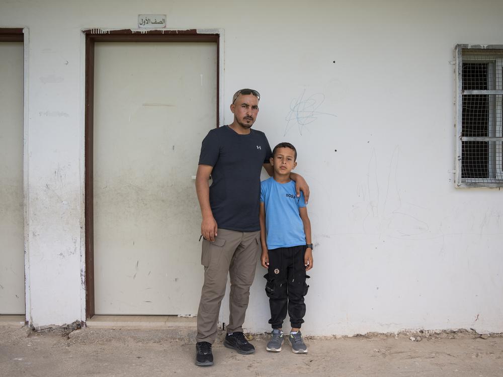Suliman Mleihat, 32, and his nine-year-old son Obeida stand in front of Obeida's classroom, where he sheltered from settlers who attacked the school in the Mu’arrajat Bedouin community in mid-September.