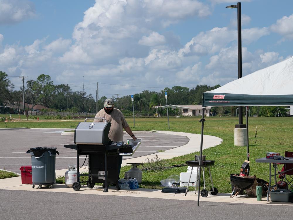 A volunteer works the grill in front of Creekside Church. Members of the church worked together throughout the day to provide food and drinks for anyone who might need it.