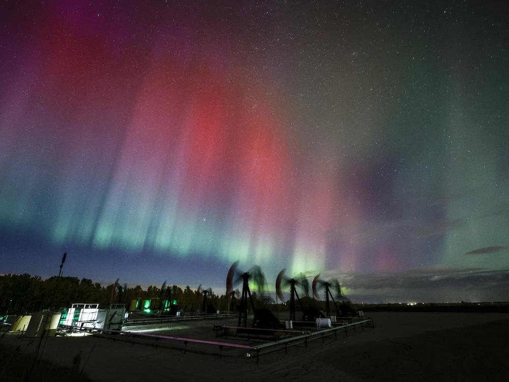 An aurora borealis makes an appearance over pumpjacks as they draw out oil and gas from well heads near Cremona, Alberta, Canada, on Oct. 10.
