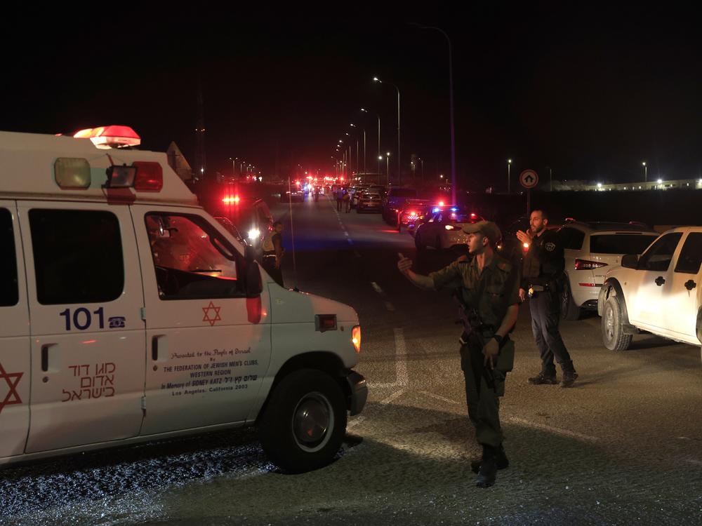 Emergency services personnel attend the scene of a drone strike launched by Hezbollah on Sunday in Binyamina, Israel.